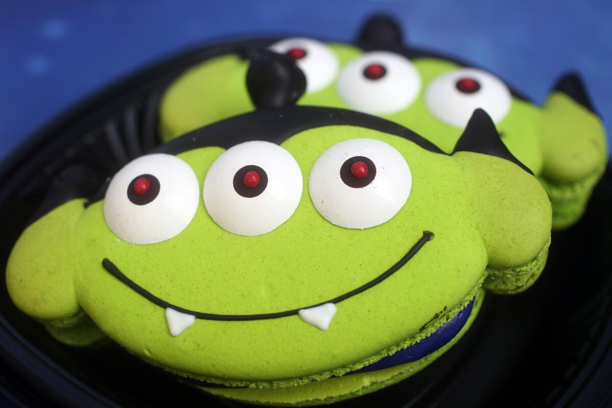 A green cookie decorated to look like a vampire.