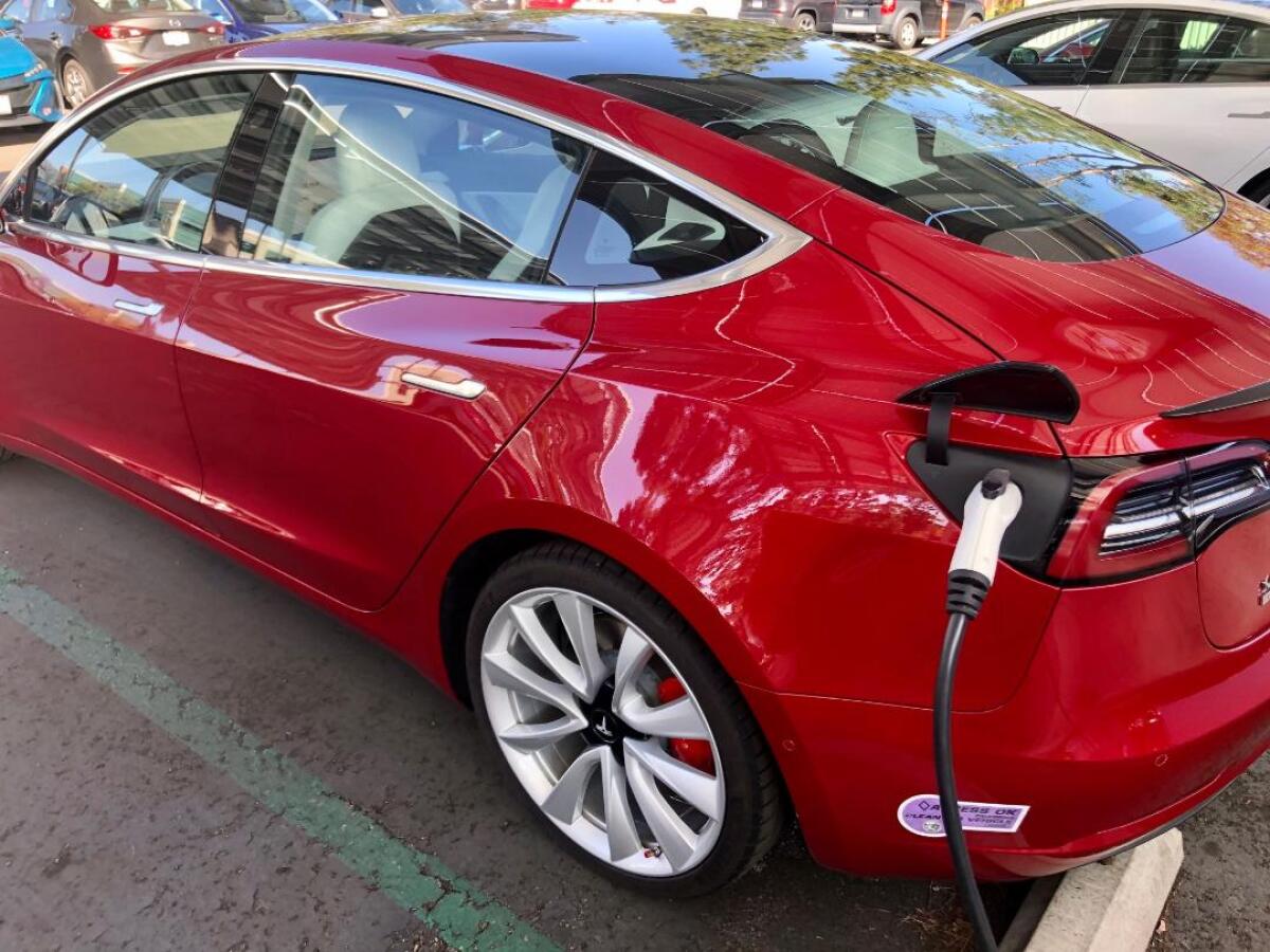 A Tesla getting charged in a parking lot near Rancho Bernardo.