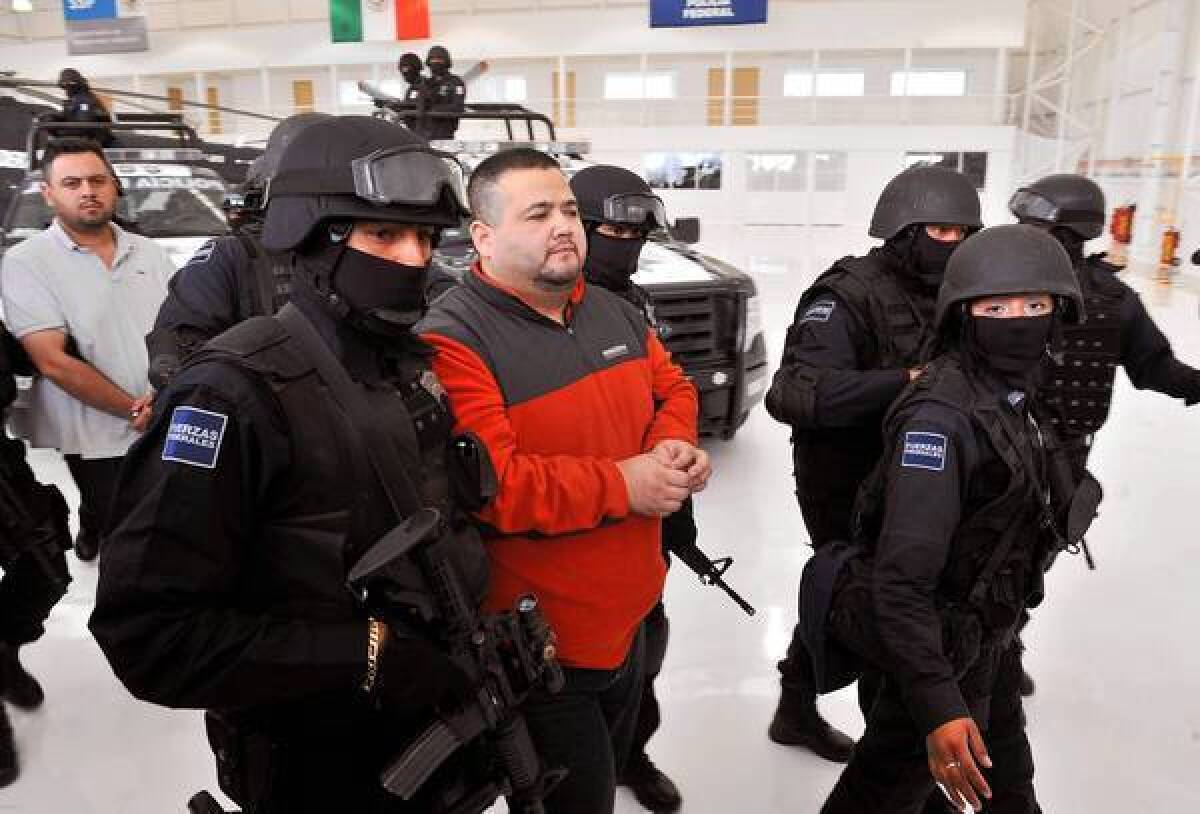 Teodoro "El Teo" Garcia Simental is held by police in Mexico City in 2012. He had been captured on the roof in his underwear, trying to escape officers.