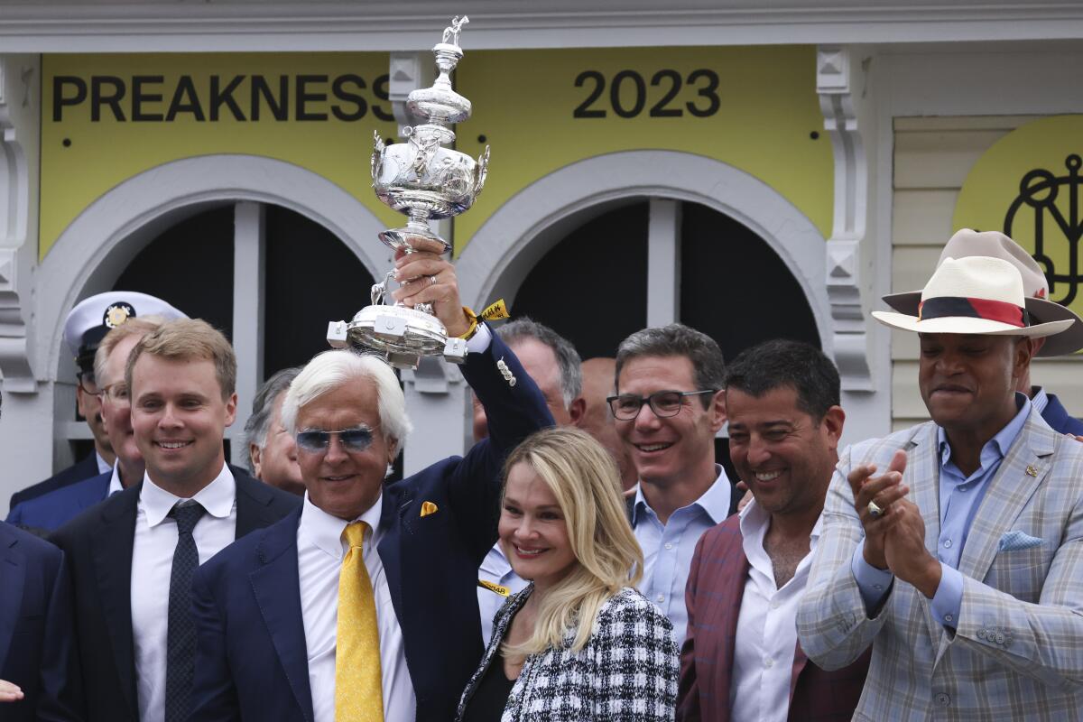 Bob Baffert, second from left, trainer of National Treasure, hoists The Woodland Vase.