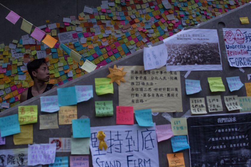 A protester looks at messages stuck to a wall outside the Hong Kong Government Complex on Saturday.