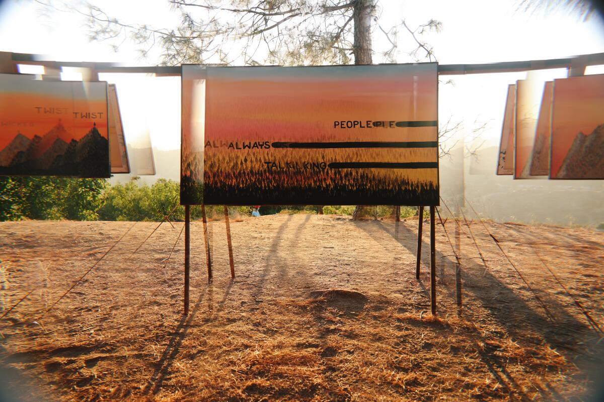 Artwork by Senon Williams on a wooden rig at sunset.