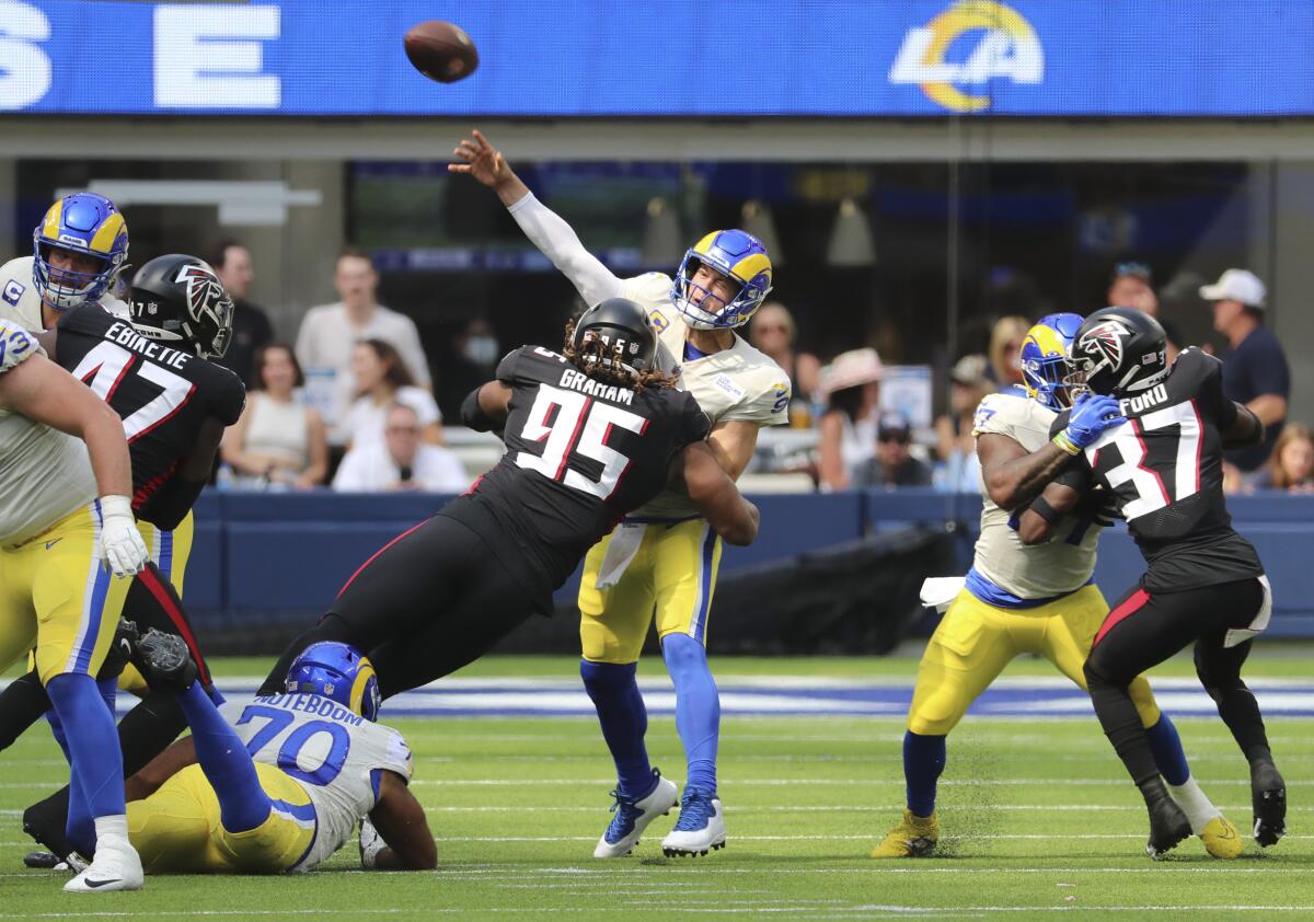 The Falcons' Ta'Quon Graham (95) hits Rams quarterback Matthew Stafford as he throws in the first half.