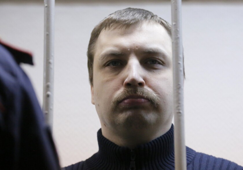 Mikhail Kosenko stands in a defendants' cage during sentencing at a district court in Moscow on Tuesday. Kosenko, one of 28 people arrested after clashes broke out between demonstrators and police at a protest on May, 6, 2012, was convicted and sentenced to forced psychiatric treatment.