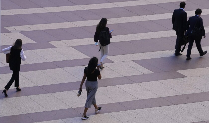 Mujeres caminan hacia unas oficinas en Madrid, España, el 17 de mayo de 2022. (AP Foto/Paul White)