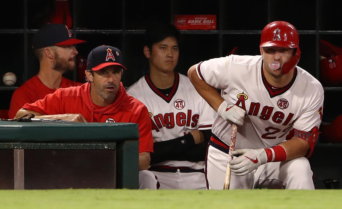 Angels manager Brad Ausmus stands next to slugger Mike Trout during a game against the Chicago White Sox in August.