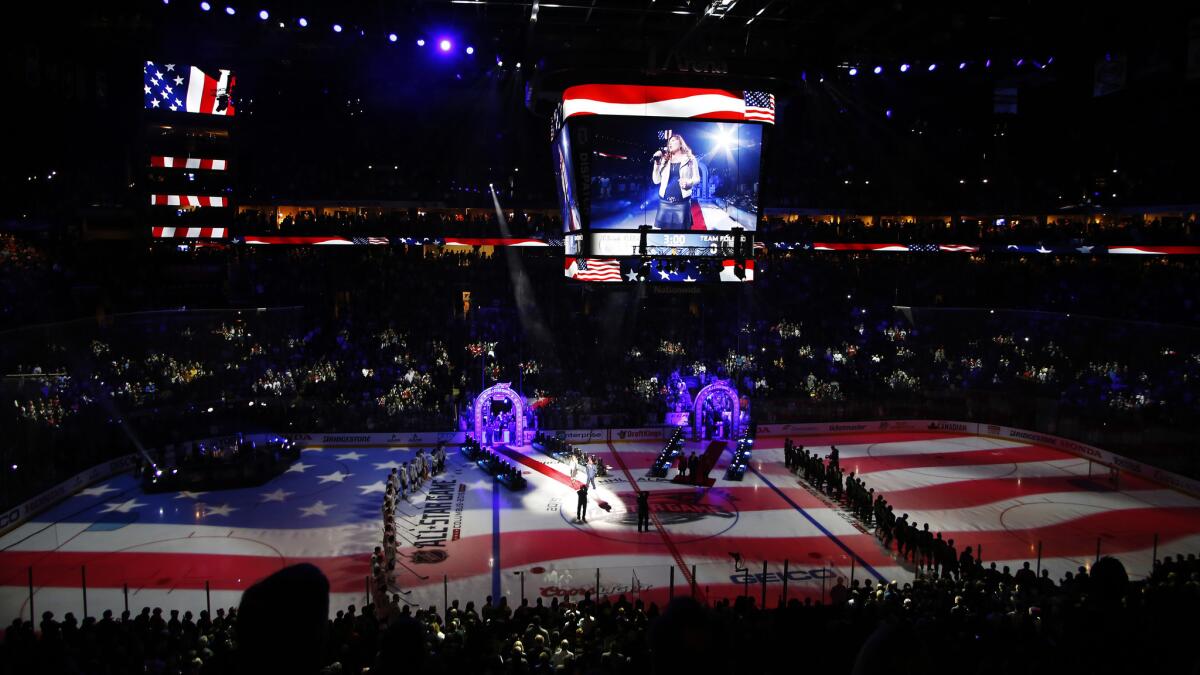 Players and fans stand for the singing on the national anthem before the start of the NHL All-Star game in Columbus, Ohio, on Jan. 25.