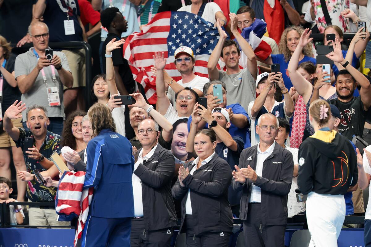 Fans in the stands cheer after Katie Ledecky receives a gold medal.