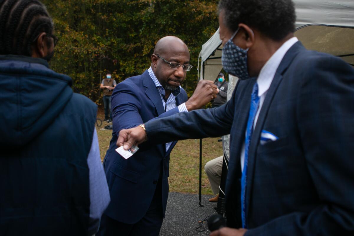 Georgia Senate candidate Rev. Raphael Warnock greets Rev. Ralph Huling on a visit to St. James Missionary Baptist Church.