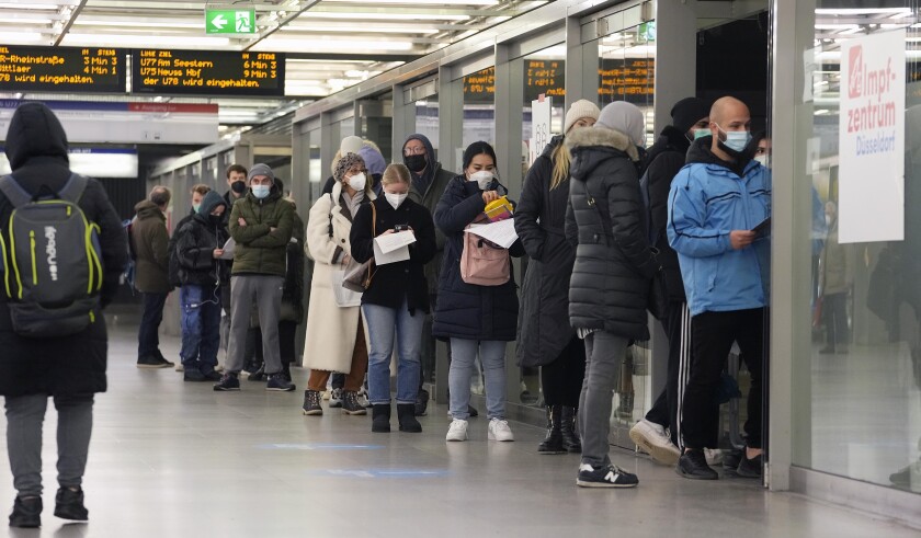 People line up at a vaccination center to get vaccinated against the coronavirus in a subway station in Duesseldorf, Germany, Monday, Dec. 6, 2021. (AP Photo/Martin Meissner)