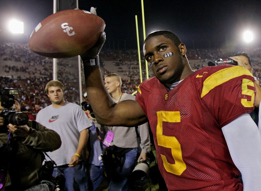 A USC player holds up a football.