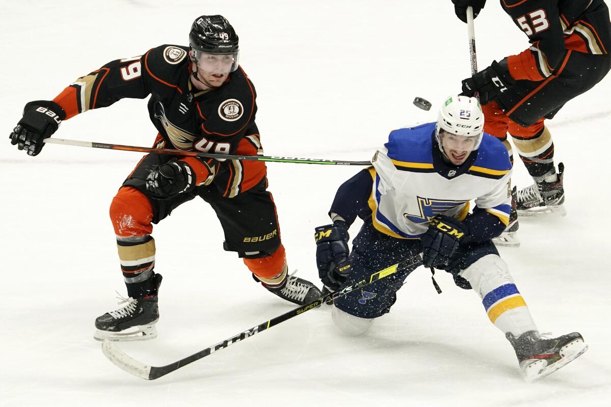 St. Louis Blues center Jordan Kyrou falls as he battles for the puck with Ducks left wing Max Jones.