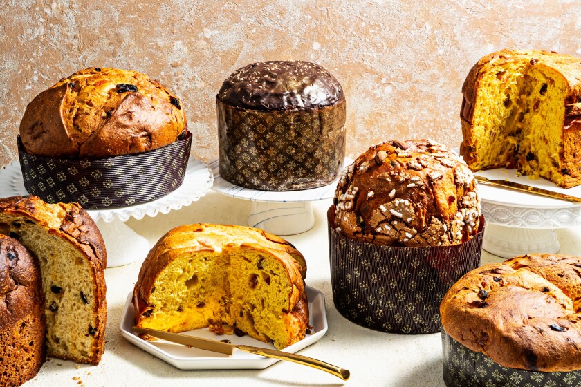 An array of panettone varieties, each with a domed top and additions, such as raisins, candied fruit, nuts and chocolate.