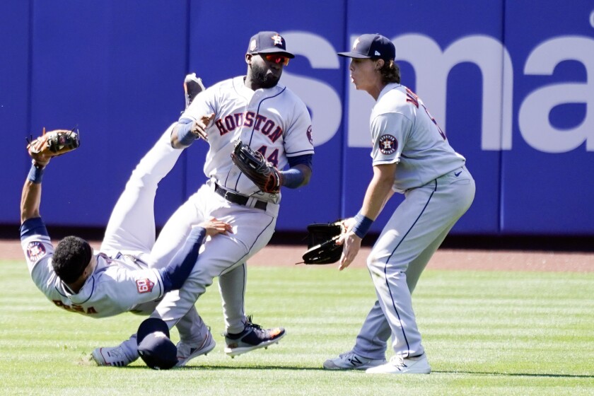 Houston Astros' Yordan Alvarez (44) collides with Jeremy Pena, left, while trying to catch a fly ball hit by New York Mets' Dominic Smith during the eighth inning of a baseball game, Wednesday, June 29, 2022, in New York. Looking on at right is Astros' Jake Meyers. (AP Photo/Mary Altaffer)