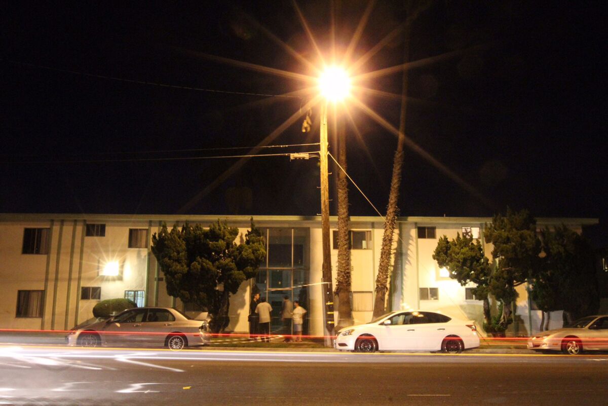 Residents stand outside 23028 Arlington in Torrance as traffic lights flash by, where Chris Harper-Mercer lived until 2010.