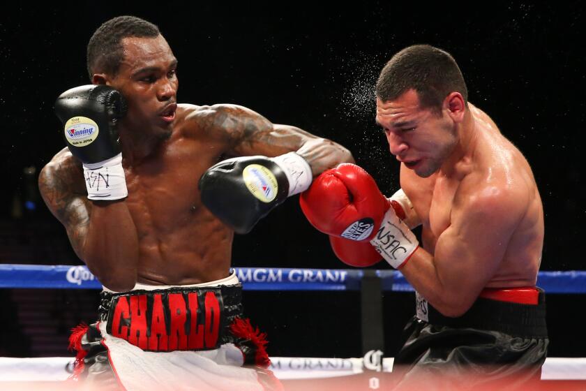 Jermell Charlo, left, trades punches with Mario Lozano during a bout on Dec. 13, 2014, in Las Vegas.