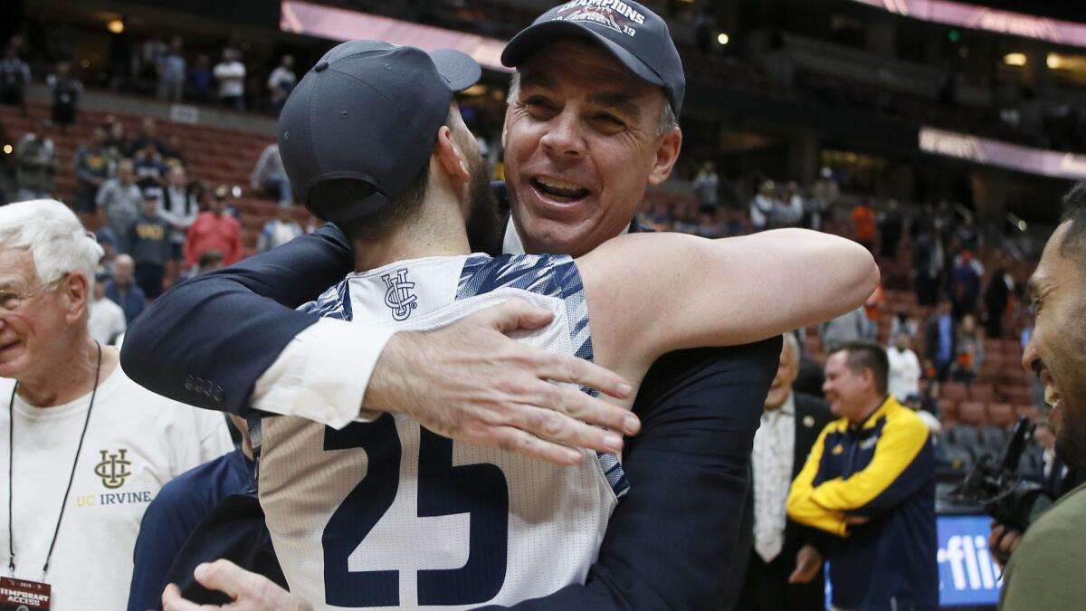 UC Irvine coach Russell Turner embraces guard Spencer Rivers after the Anteaters beat Cal State Fullerton for the Big West Conference tournament championship.