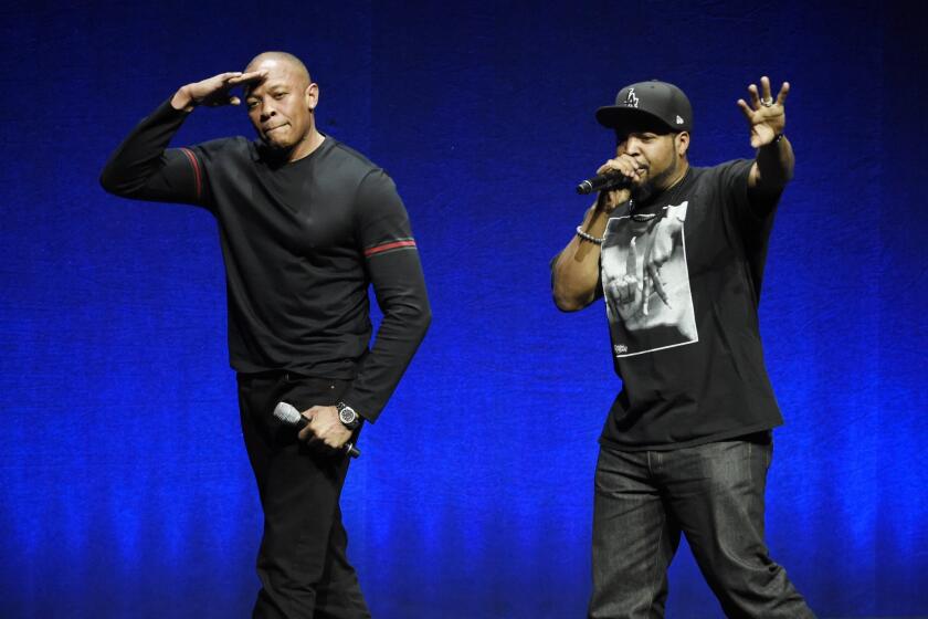 N.W.A. members Dr. Dre, left, and Ice Cube, two of the subjects of the upcoming biographical drama "Straight Outta Compton," salute the crowd after speaking at the Universal Pictures presentation during CinemaCon in Las Vegas on April 23.