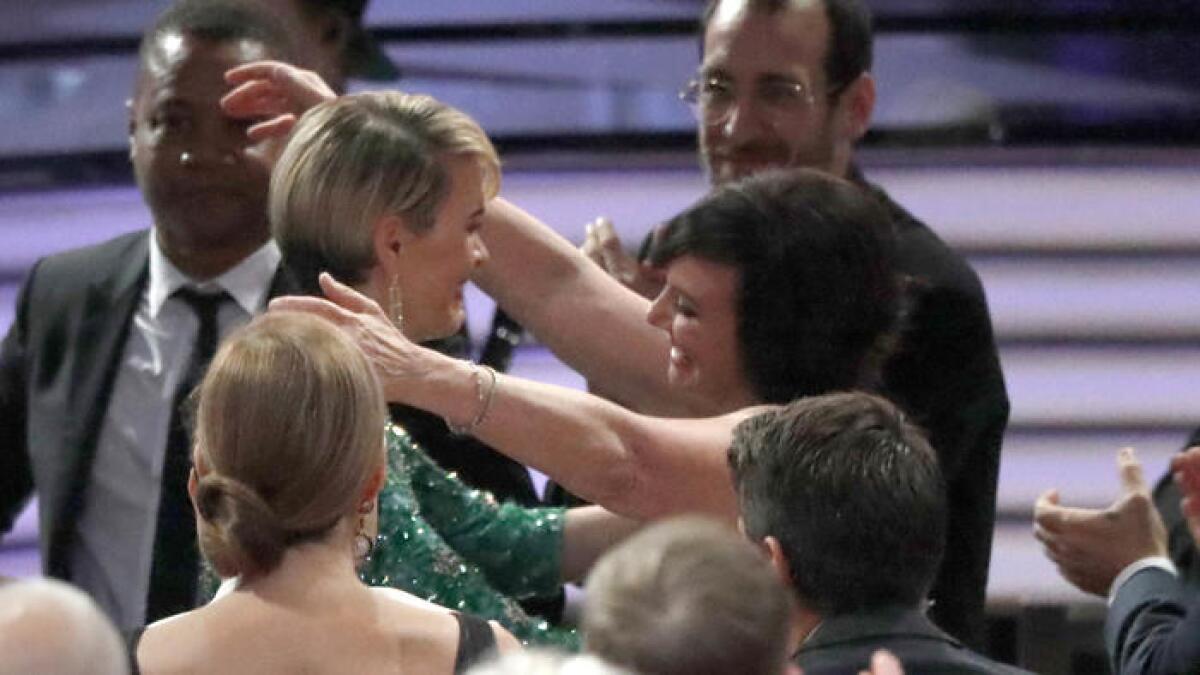 Sarah Paulson, center, hugs Marcia Clark after winning the Emmy for lead actress in a limited series or movie at the Emmy Awards at the Microsoft Theater in Los Angeles.