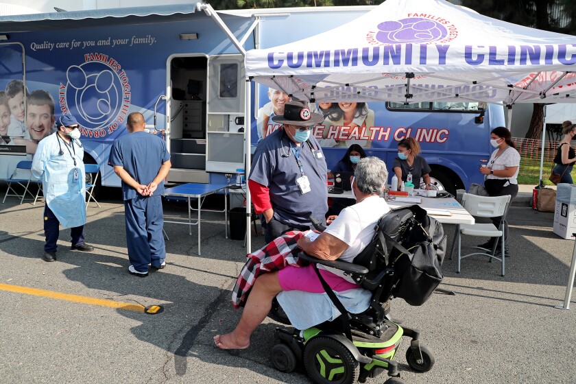 A health professional speaks with a visitor to a health clinic at an August 2021 Navigation Day hosted by the city of Orange.