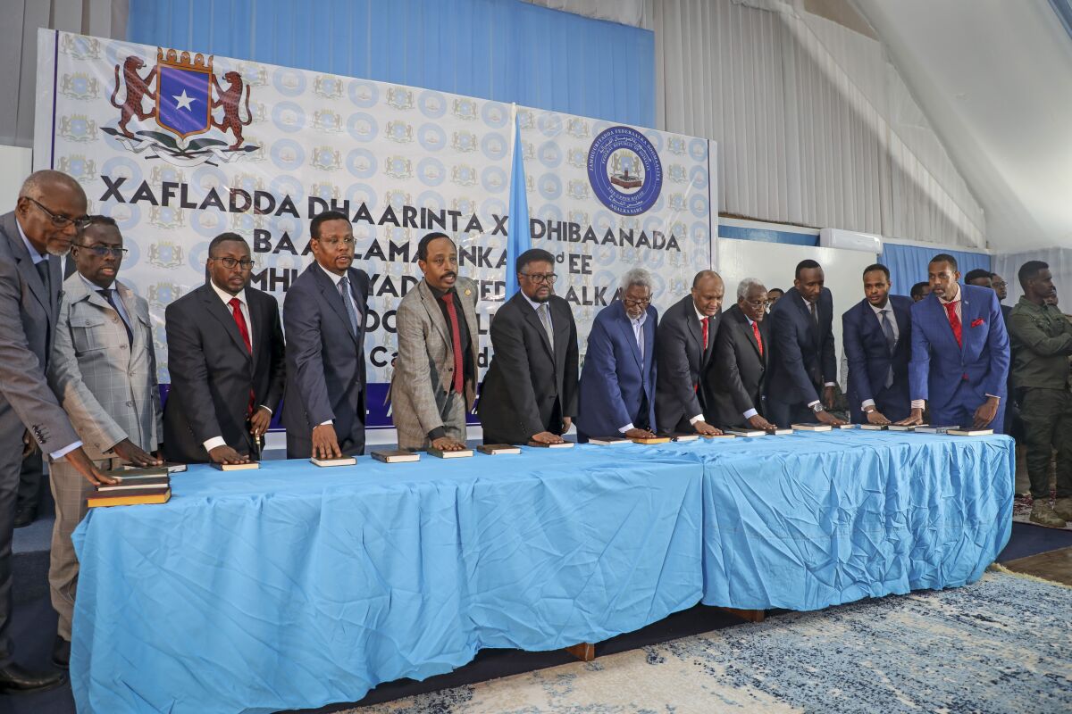 Somali lawmakers are sworn-in to office at a ceremony held in the capital's heavily fortified Halane military camp, in Mogadishu, Somalia Thursday, April 14, 2022. Somalia on Thursday inaugurated 290 new lawmakers, bringing the country a step closer to completing a prolonged electoral process marred by alleged corruption and irregularities. (AP Photo/Farah Abdi Warsameh)