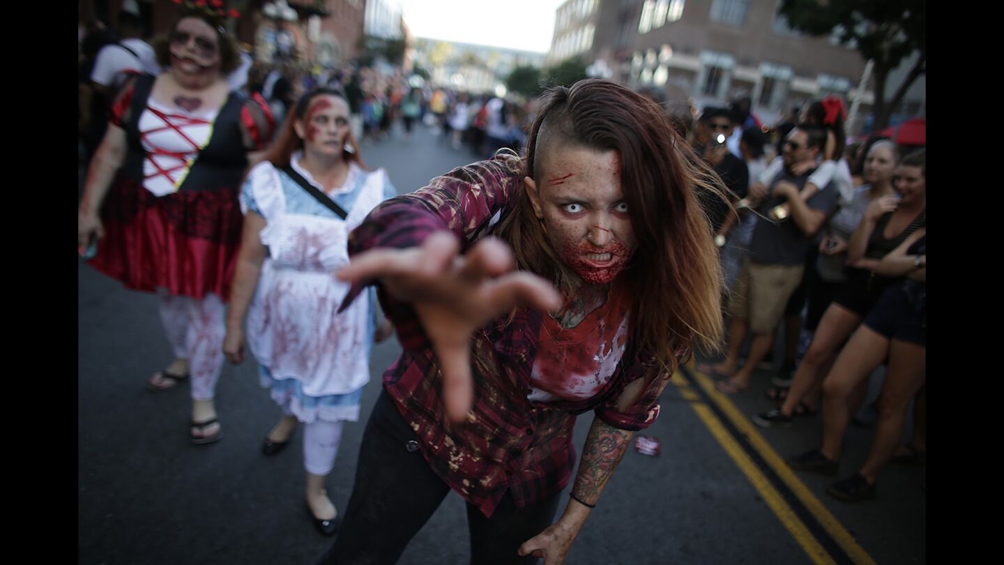 Zombie cosplayers parade along Fifth Avenue during a Zombie Walk event at Comic-Con 2016.