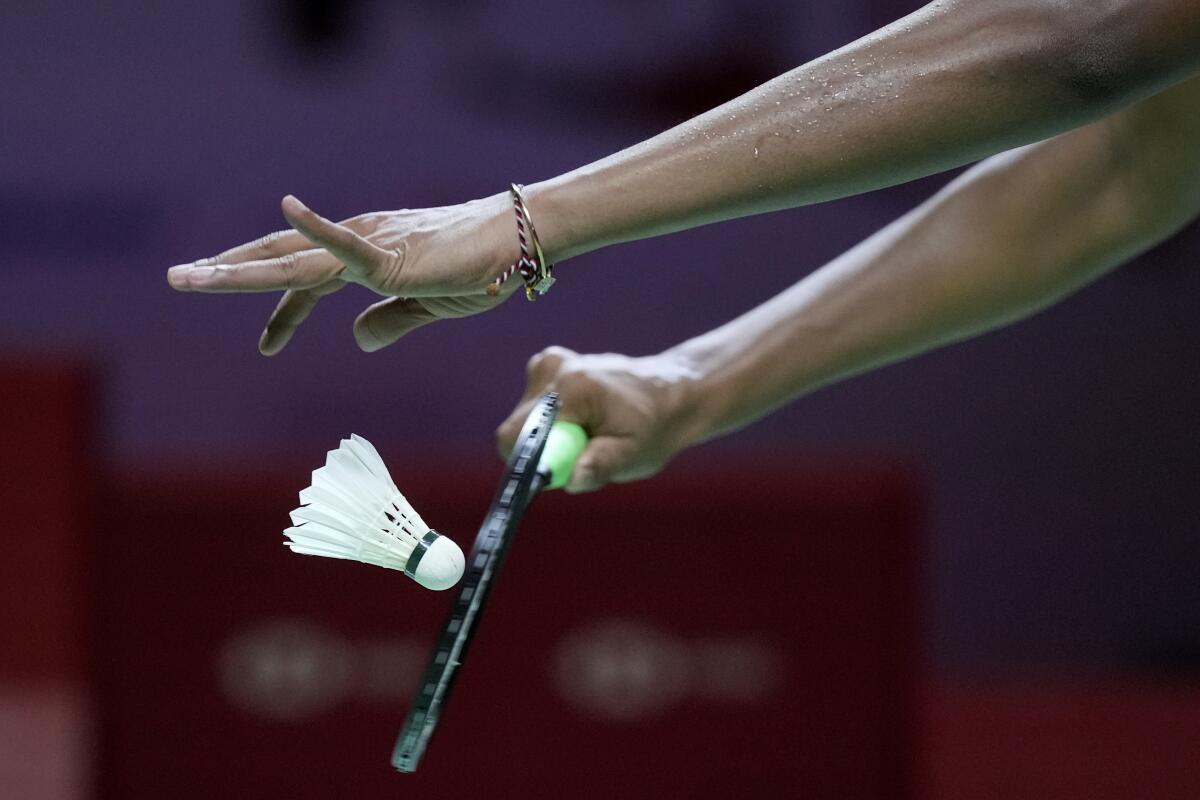 A shuttlecock is struck by a badminton racket on a serve.