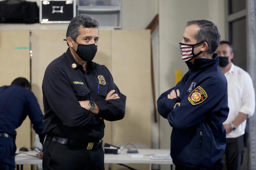 LOS ANGELES, CA - DECEMBER 28: Ralph M. Terrazas, left, Fire Chief of the Los Angeles Fire Department (LAFD) and Mayor of Los Angeles Eric Garcetti, talk while personnel of the LAFD receive the Moderna COVID-19 vaccination at LAFD Station 4 on Monday, Dec. 28, 2020 in Los Angeles, CA. Mayor of Los Angeles Eric Garcetti and Ralph M. Terrazas, Fire Chief of the Los Angeles Fire Department, were there to observe the rollout of the vaccination program. (Gary Coronado / Los Angeles Times)