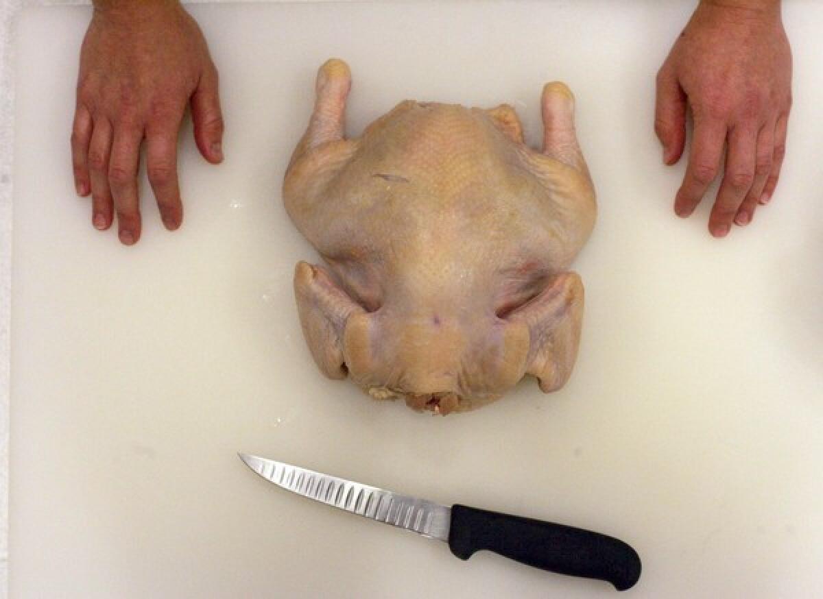 Place the chicken breast-side down on a cutting board, and begin the boning process.