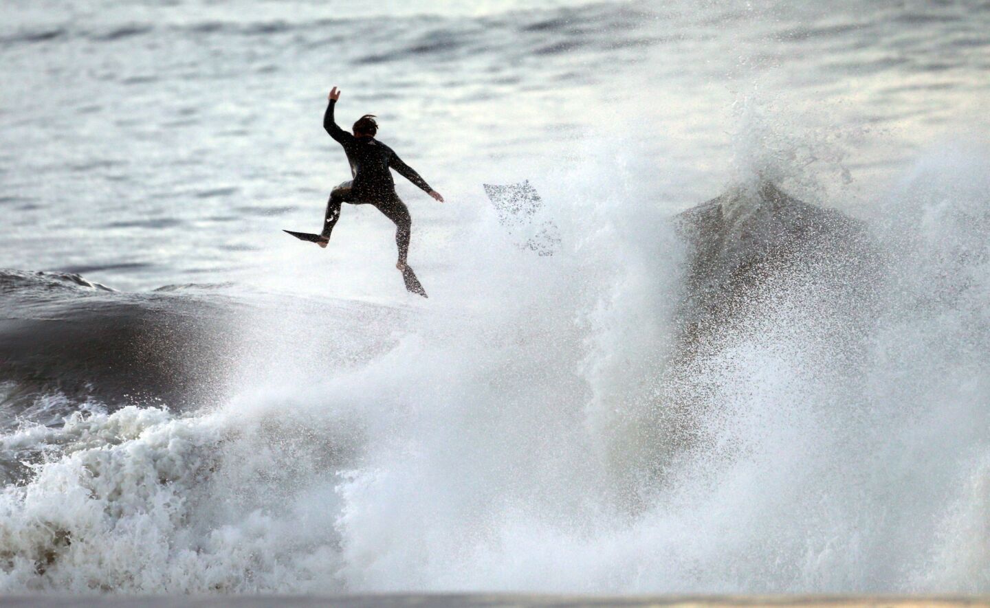 A body boarder is tossed from his board in heavy surf off the Seal Beach Pier Thursday morning.