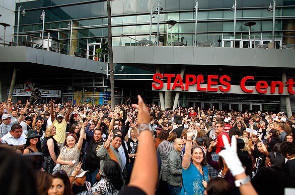 A fan gets the crowd going with words from a Michael Jackson song outside Staples Center.