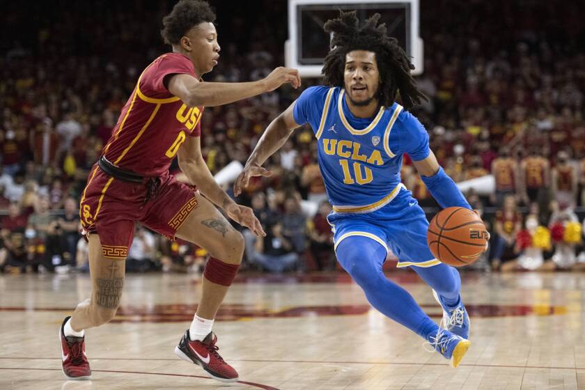 UCLA's Tyger Campbell drives to the basket against USC's Boogie Ellis during the first half.