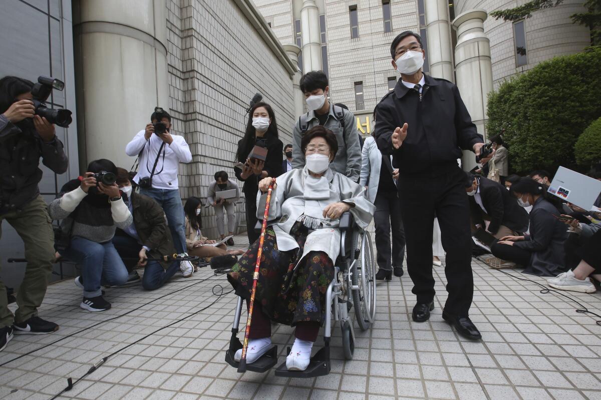 An elderly female plaintiff leaves court in a wheelchair
