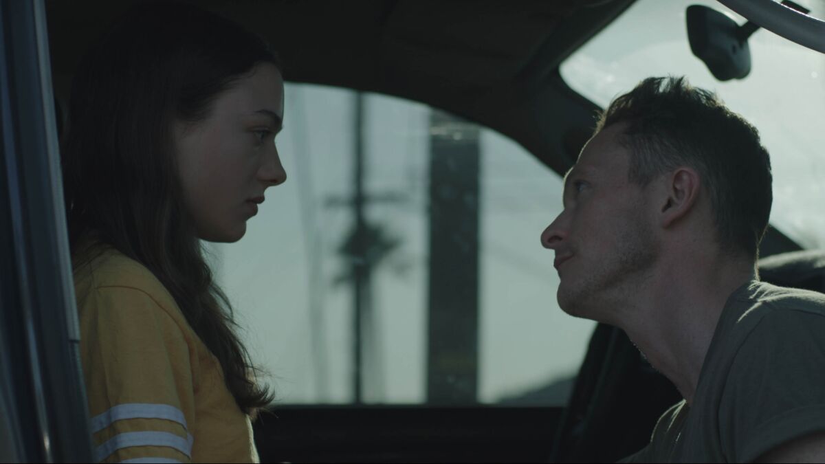 A teenage female and middle aged man at each other in a scene from "Palm Trees and Power Lines"