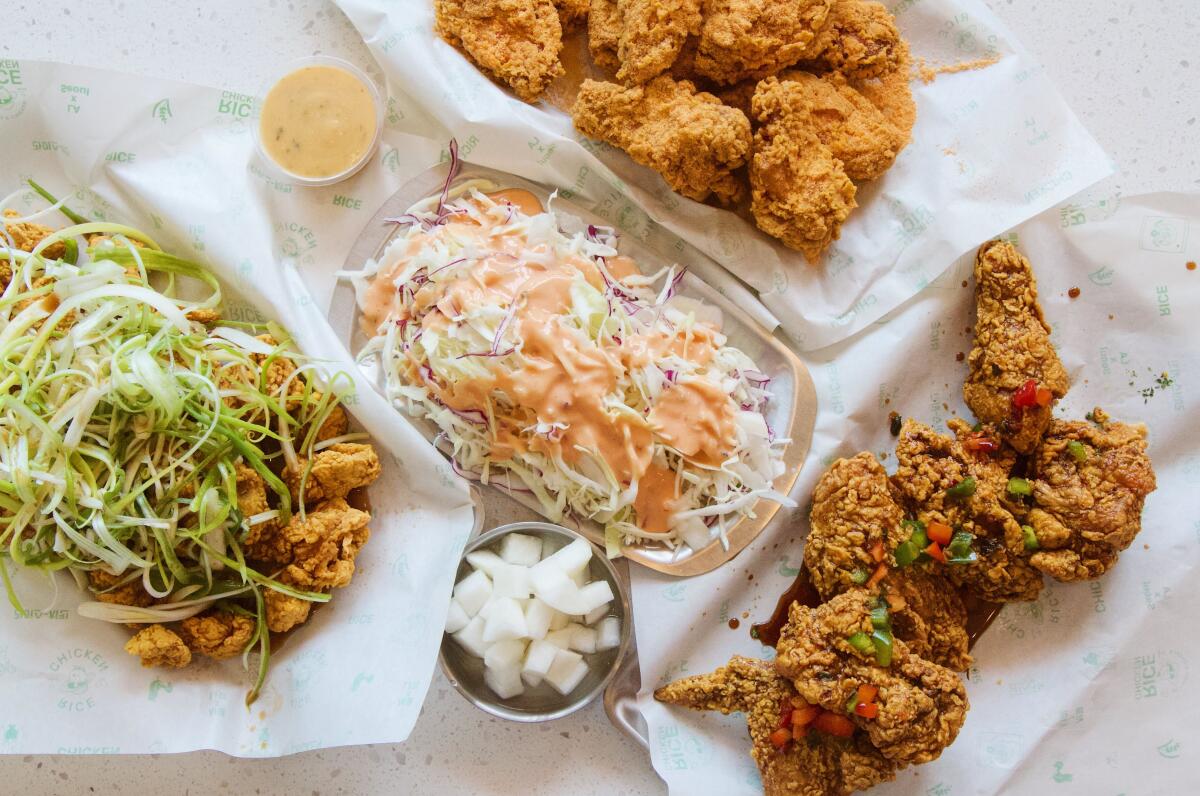 An overhead photo of three types of Korean fried chicken, with a plate of cabbage salad.
