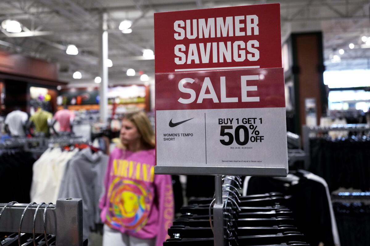 A sale sign is displayed for clothes at a retail store