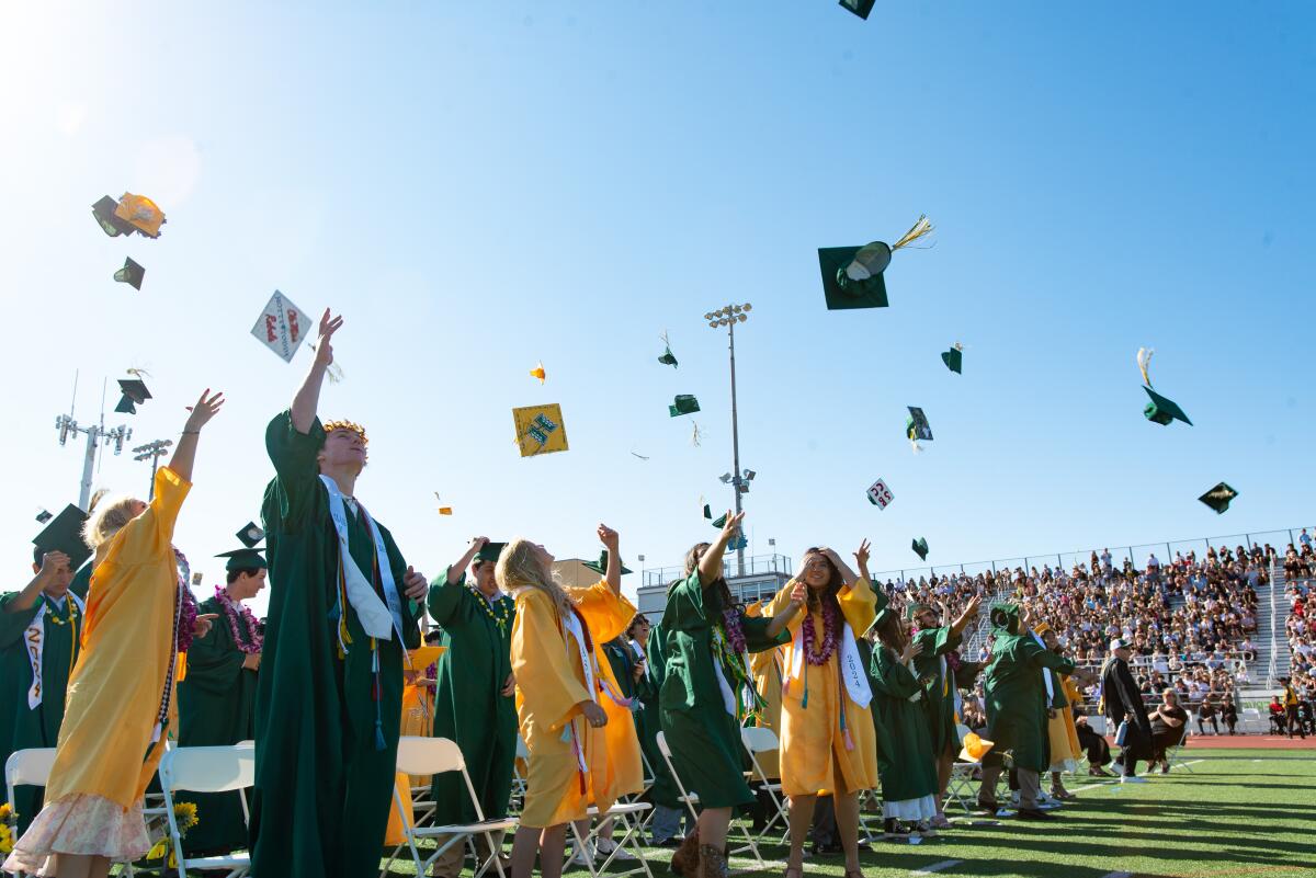 Graduating Edison High seniors toss their caps into the air during their commencement ceremony on Thursday.