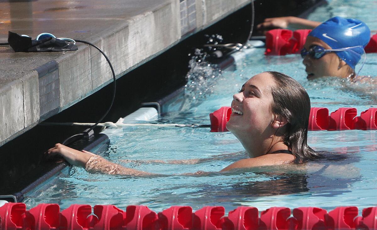 Burroughs' Maya Wilson looks up at a teammate after winning the 200 individual medley, setting a new school record, in a dual Pacific League swim meet between Burbank and Burroughs at Burroughs High School on Wednesday, April 17, 2019.