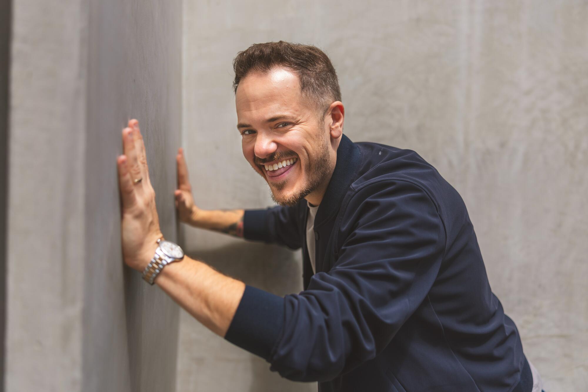 O comediante Jeff Arcuri posando contra uma parede
