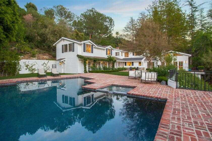 The 1.5-acre spread includes a swimming pool, tennis court and L-shaped home built in the 1970s.