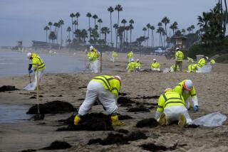 FILE - Workers in protective suits clean the contaminated beach in Corona Del Mar after an oil spill in Newport Beach, Calif., Oct. 7, 2021. The Pipeline and Hazardous Materials Safety Administration is proposing a nearly $3.4 million fine for Amplify Energy Corp over the oil pipeline spill that fouled Southern California beaches.(AP Photo/Ringo H.W. Chiu, File)