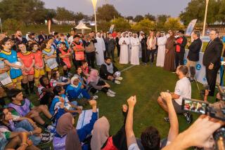 Secretary of State Antony J. Blinken speaks to young people on a soccer pitch in Qatar