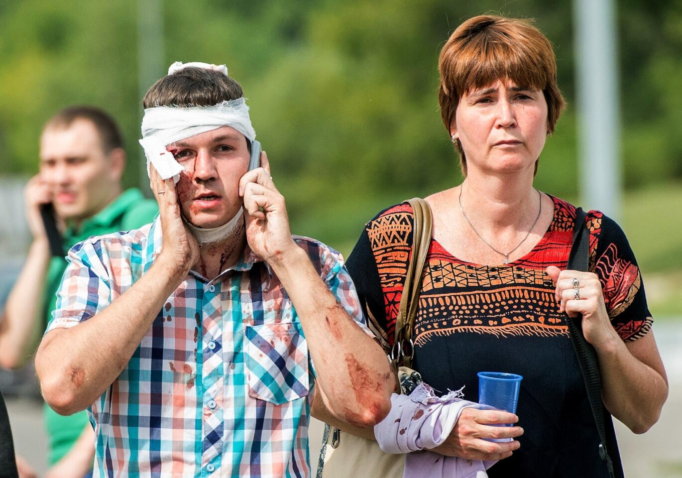 An injured passenger speaks on his phone after several subway cars derailed in Moscow.