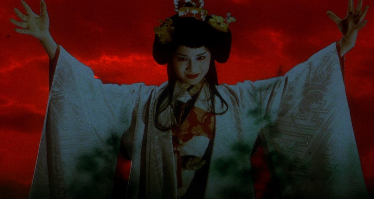 A woman in a kimono raises her arms