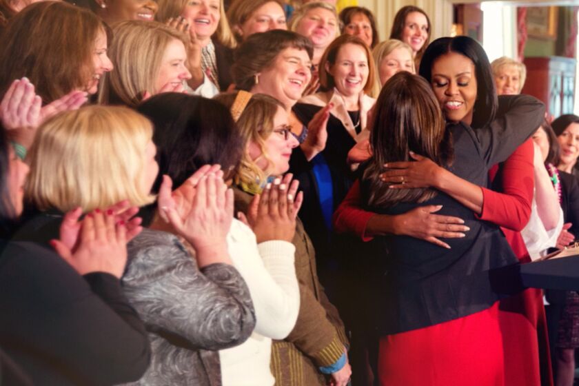 Michelle Obama, as First Lady, embraces an admirer, as seen in the Netflix documentary "Becoming."