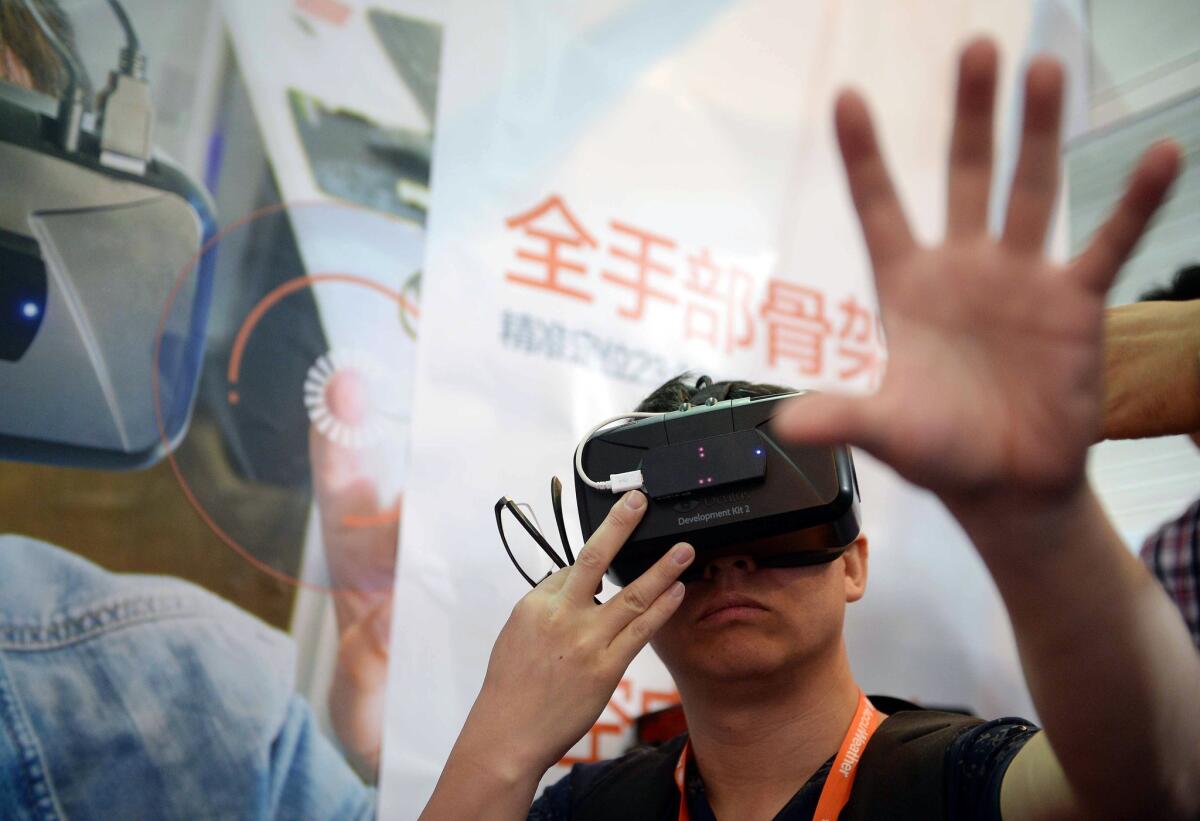 A visitor tries on virtual reality glasses from Oculus Rift Development Kit 2 (DK 2) during the first Consumer Electronics Show (CES) in Asia in Shanghai.