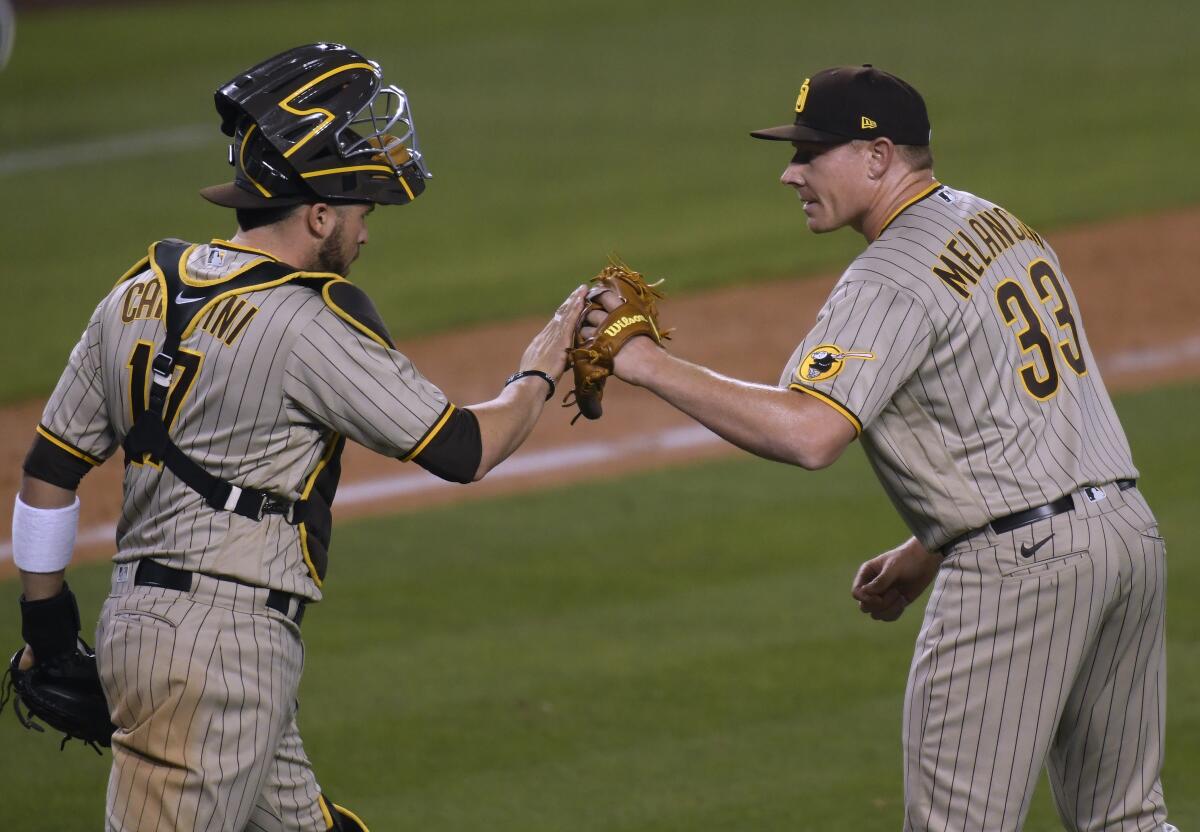 The Padres' Mark Melancon, right, and Victor Caratini celebrate a 3-2 win over the Dodgers on April 22, 2021.