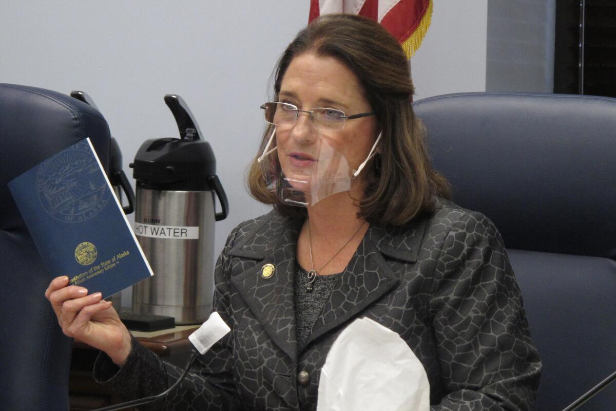 La senadora de Alaska, Lora Reinbold, sostiene una copia de la Constitución de Alaska.