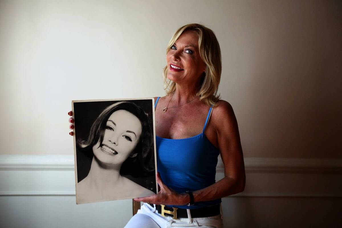 Robin Greer holds a photograph of her mother, model Dolores Greer, who died last month at 81. Autograph collector Scott Smith spent decades trying to track down the identity of Dolores Greer, who appeared on the cover of the Oct. 17, 1960, issue of Sports Illustrated.