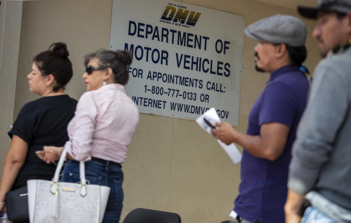People wait in line for DMV service in the San Fernando Valley. You do not need to return in person to renew your Real ID.